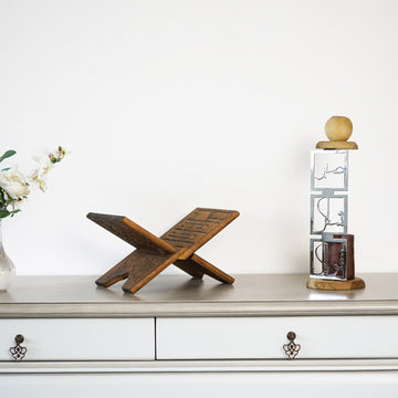 Shiny Silver Sabr Shukr Tawakkul candleholder beside a Quran stand on a white dresser