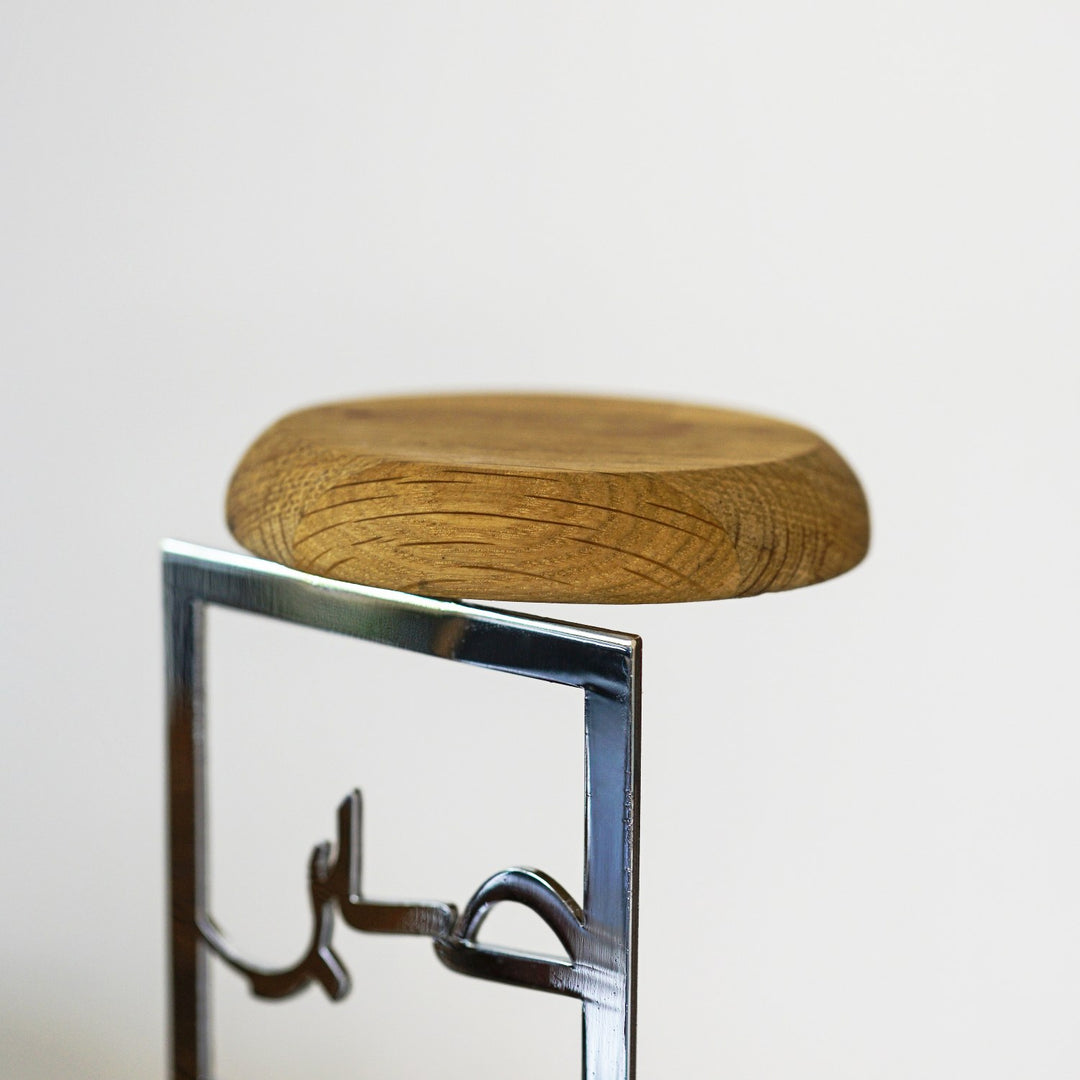 Close-up of the oak top disc resting on the Shiny Silver Sabr calligraphy frame