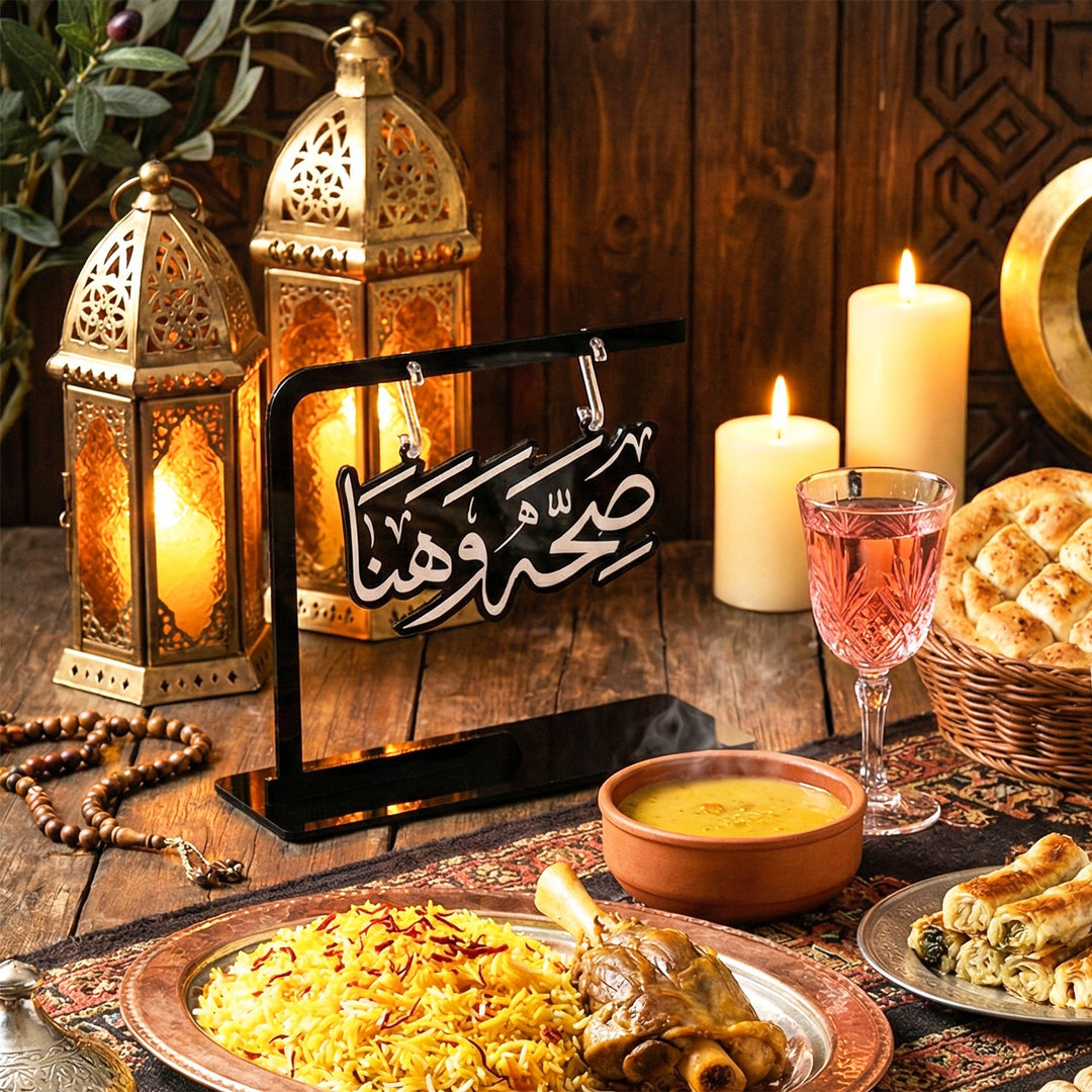 Support Saha w Hana à écriture découpée au centre d'une table d'iftar dressée avec lanternes, riz et chapelet