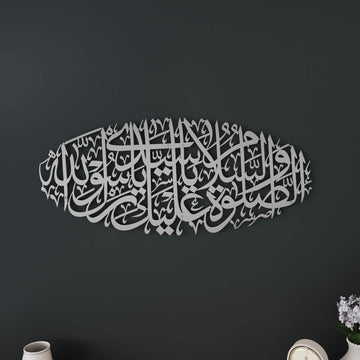 Matte Silver Salawat on Rasulullah oval metal wall art in Arabic calligraphy on a dark gray wall