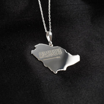 Close-up of the Silver Saudi Arabia map pendant, sword engraving below the Shahada, polished surface