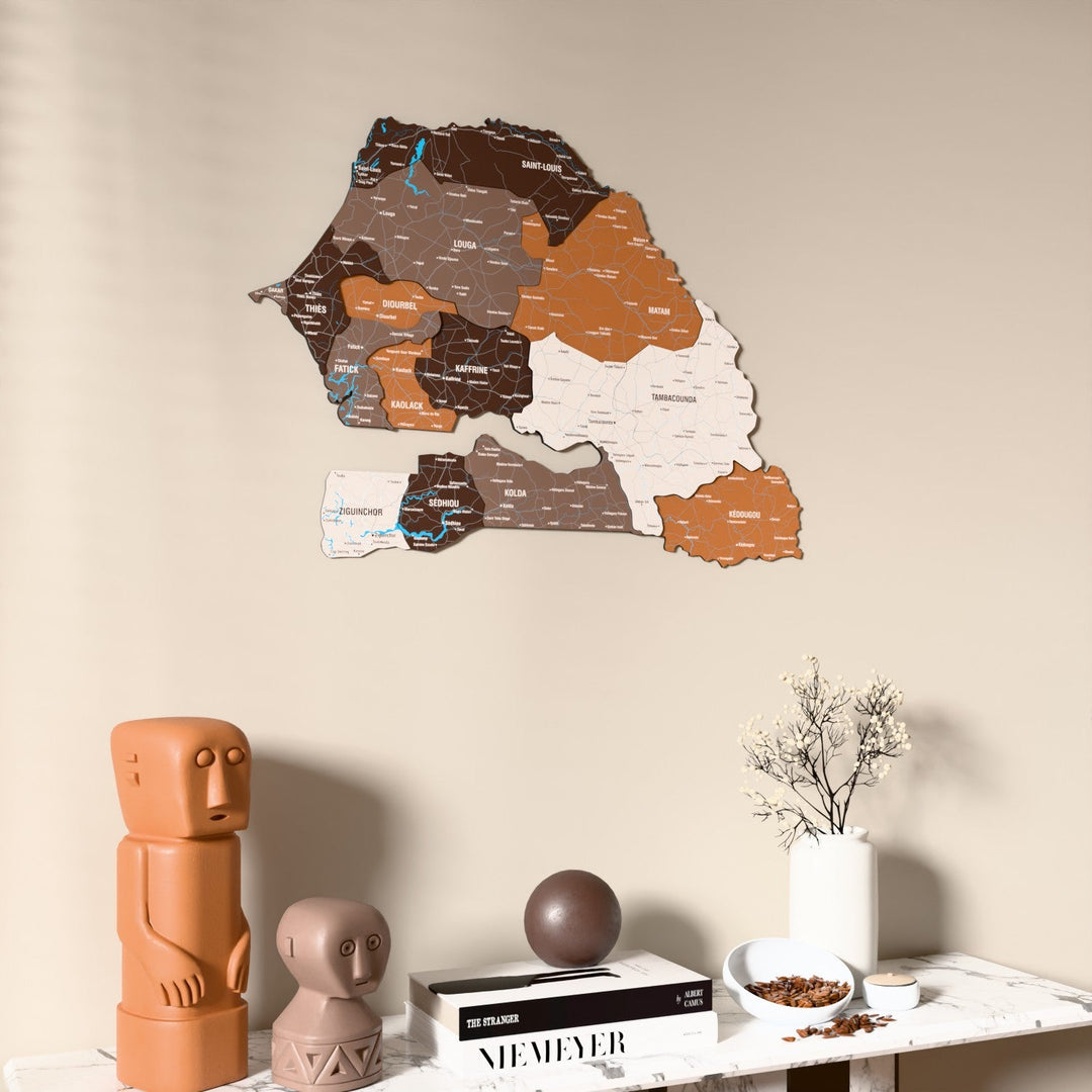 Soil Senegal wooden wall map on a beige wall above a console with figurines