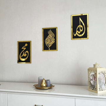 Basmala, Allah and Muhammad wooden wall art set, Gold on Black, hung at different heights above a white sideboard