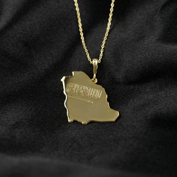 Close-up of the Gold Saudi Arabia map pendant showing the engraved Shahada and sword