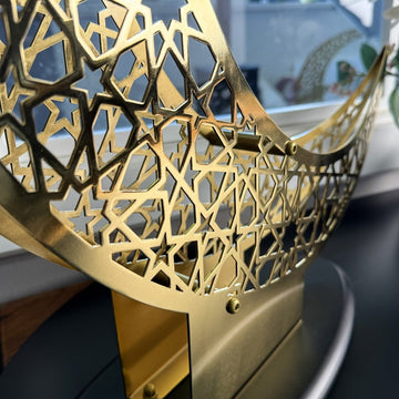 Close-up of the Shiny Gold crescent's lower curve with star pattern cut-outs and base screws