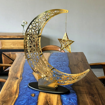 Shiny Gold crescent and star decor on a walnut dining table with a blue resin runner