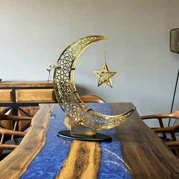 Shiny Gold crescent and star decor on a walnut table with a blue resin runner, wider view