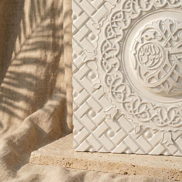 Gros plan sur le treillis géométrique du relief en pierre et le médaillon rond de calligraphie arabe