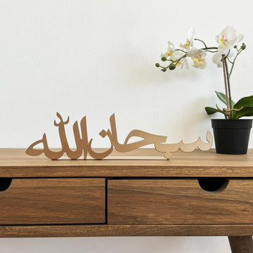 ديكور طاولة معدني نحاسي «سبحان الله» على مكتب خشبي، منظر أمامي مع زهرة أوركيد