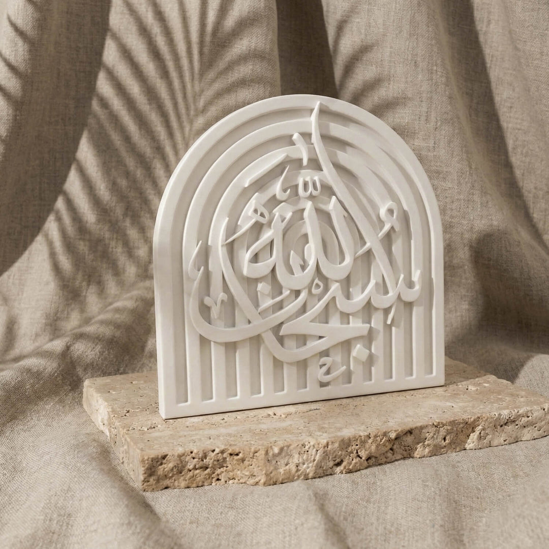 SubhanAllah stone relief arch plaque, slightly angled on a stone slab in front of linen