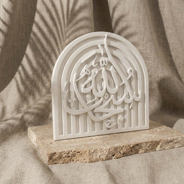 SubhanAllah stone relief arch plaque, slightly angled on a stone slab in front of linen