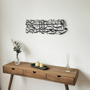 Schwarze Metall-Wandkunst mit Sure Ad-Duha, Vers 5, über einer Konsole, Schrägansicht mit Koranständer