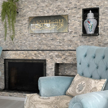 Surah Al-Alaq tempered glass wall art on a stone feature wall beside a light blue armchair