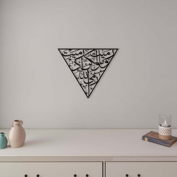 Black Surah Al-Anfal 17 triangle metal wall art above a white dresser with a candle and book