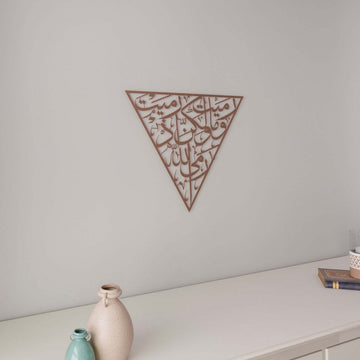 Matte Copper Surah Al-Anfal 17 triangle metal wall art above a white sideboard with a small vase