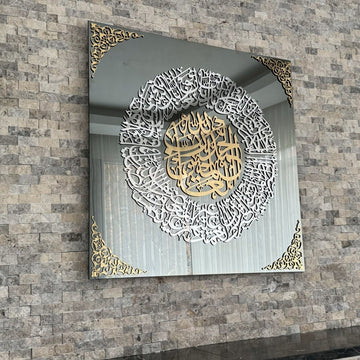 منظر مائل للوحة جدارية زجاجية بسورة الفاتحة على جدار حجري يظهر انعكاس الزجاج