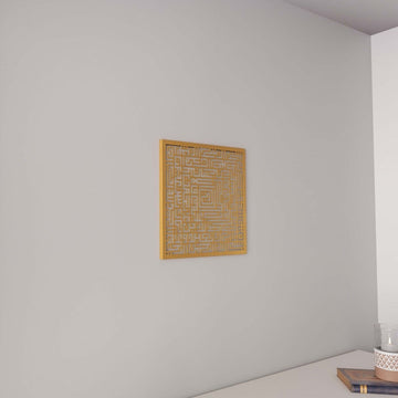 Gold square Kufic Surah Fatiha metal wall art, front view above a white console