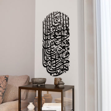 Schwarze Metall-Wandkunst mit Sure Al-Furqan, Vers 74, in senkrechter Bogenform über einer Glasvitrine