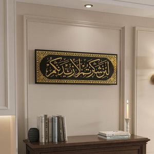 Gold Acrylic Surah Ibrahim 7 tempered glass wall art, Arabic calligraphy on black, above a wood dresser