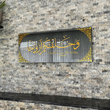 Gold Acrylic on Black Mirror Surah Naba Verse 8 tempered glass wall art, straight front view on stone