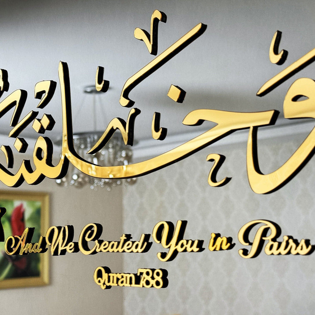 Close-up of the gold 3D wa khalaqnakum azwaja calligraphy and English line Quran 78:8