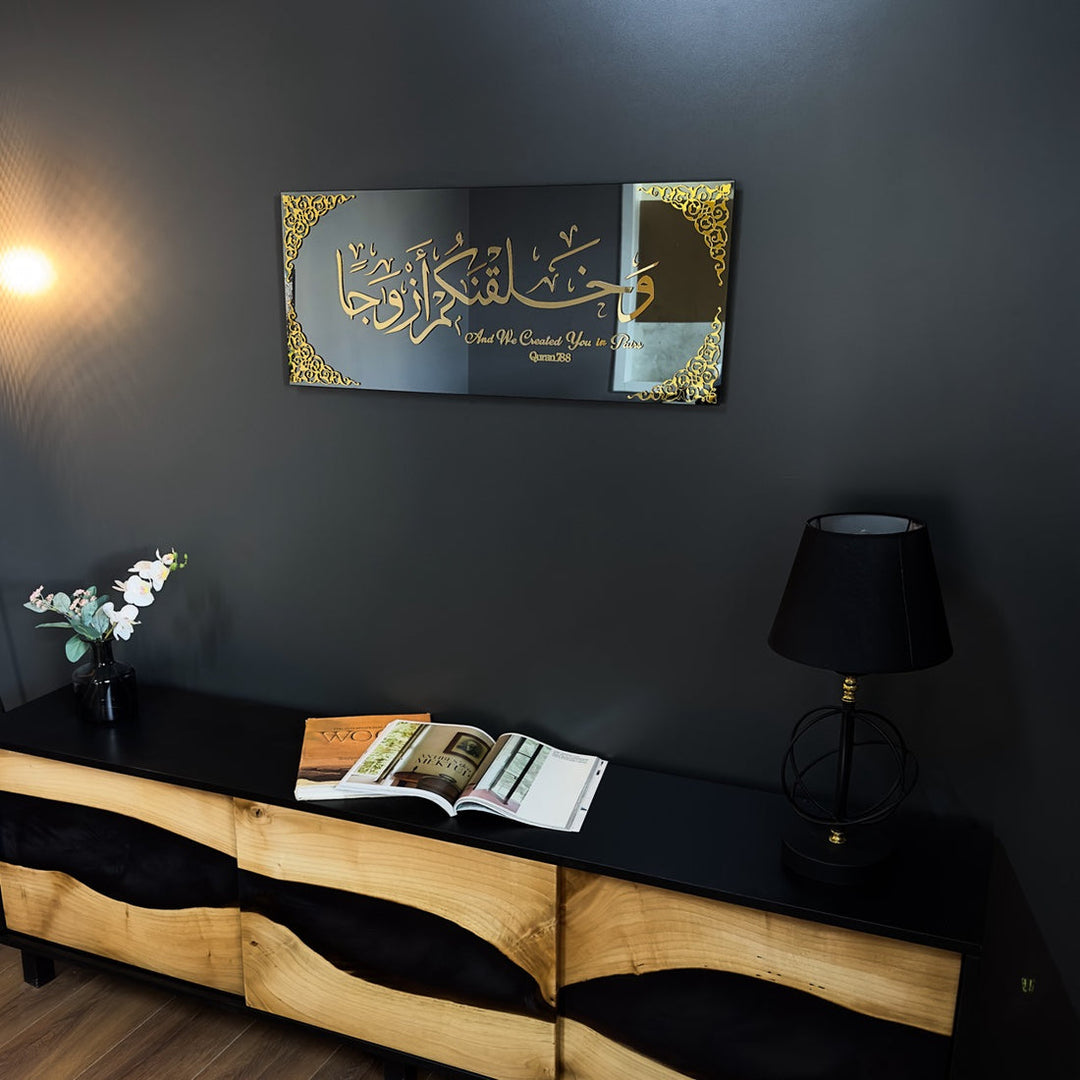 Gold Acrylic Surah Naba Verse 8 tempered glass wall art on a dark wall above a wooden media console