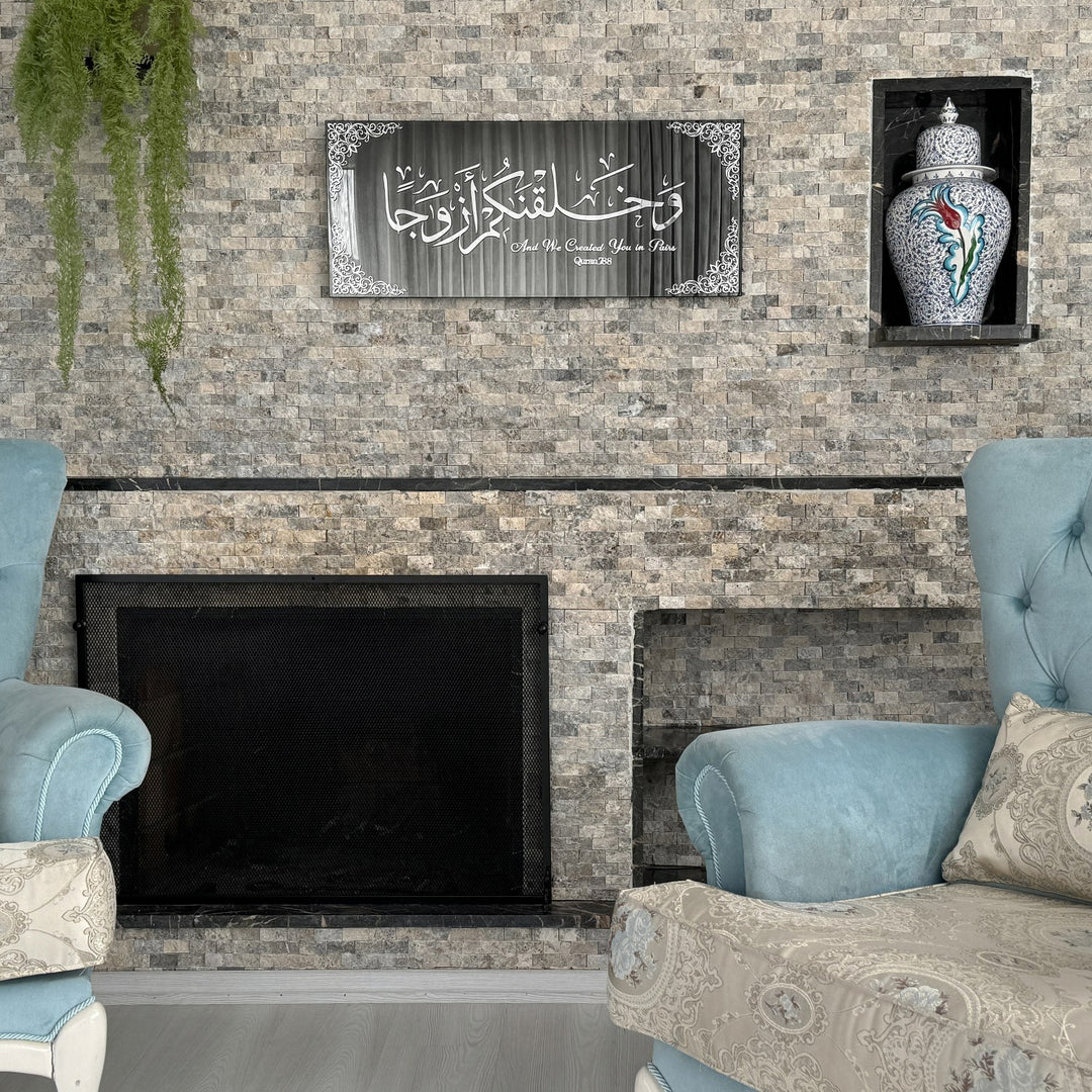 Silver Acrylic on Black Mirror Surah Naba Verse 8 tempered glass wall art above a fireplace with a decorative jar
