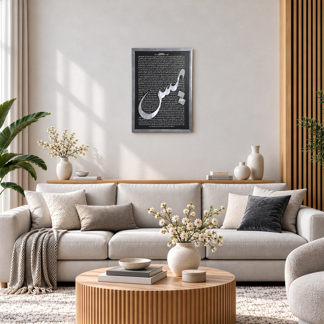 Silver framed Surah Yaseen wall art with silver acrylic Ya-Sin calligraphy, above a light grey sofa