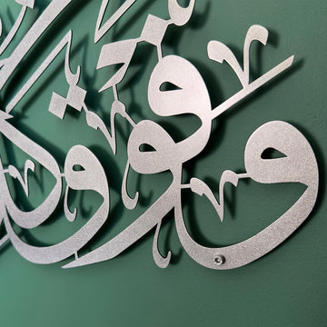 Close-up of Surah Yusuf Ayat 76 Matte Silver metal calligraphy standing off the wall