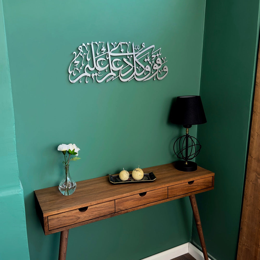 Surah Yusuf Ayat 76 Matte Silver metal calligraphy on a green wall, angled view of the table