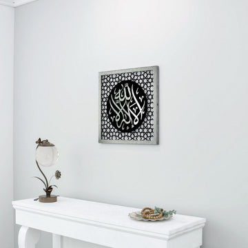 Silver Acrylic La ilaha illAllah Four Statements dhikr wooden wall art at a side angle above a console