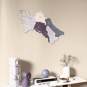 Nimbus Turkmenistan wooden wall map on a beige wall above a console with figurines