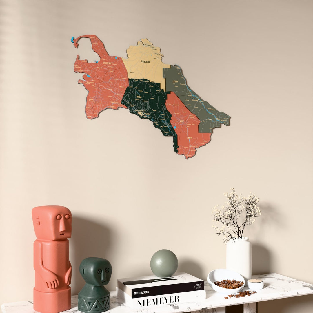 Sage Turkmenistan wooden wall map on a beige wall above a console with figurines