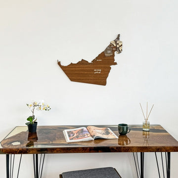 United Arab Emirates wooden wall map hung over a desk with an open magazine, centered view