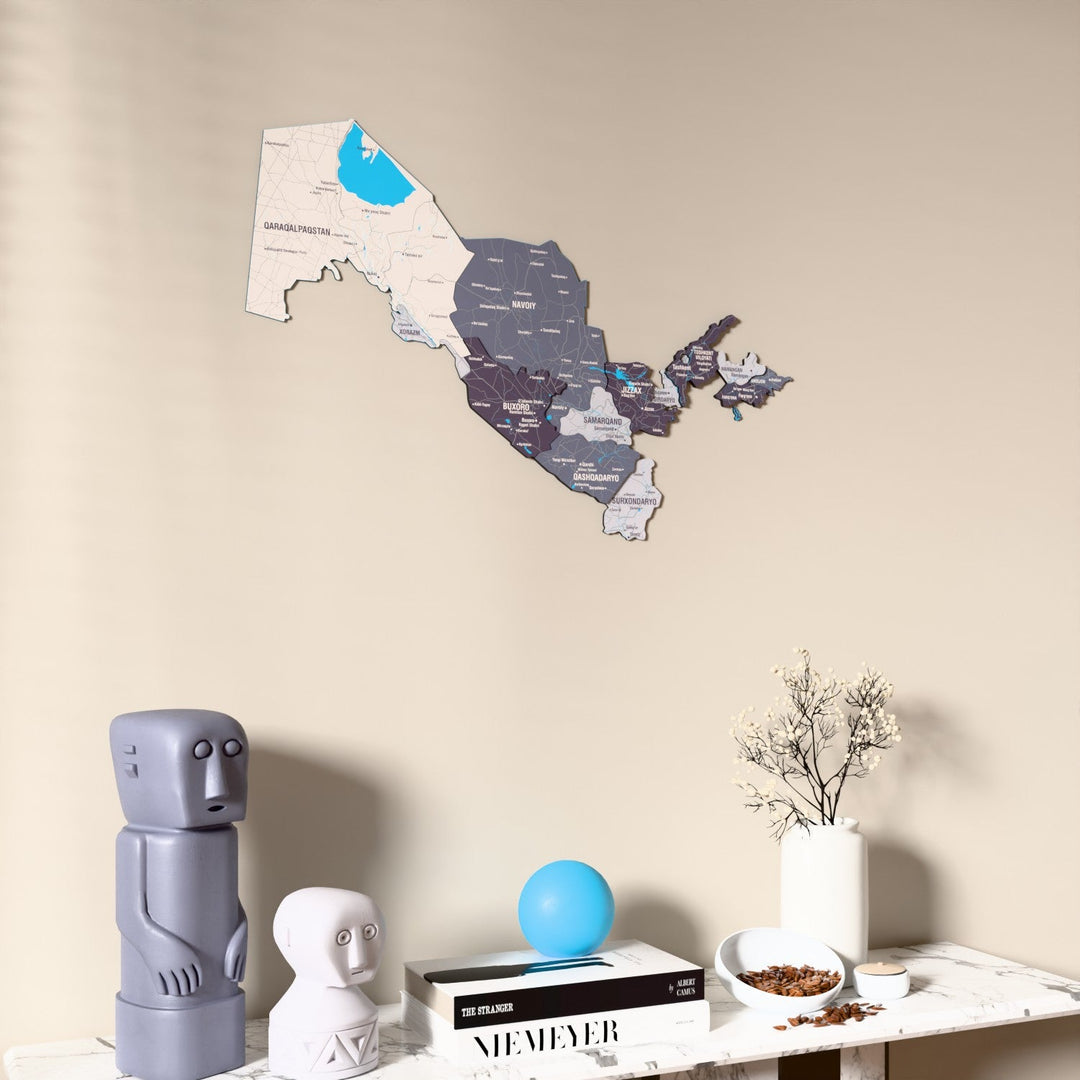 Nimbus Uzbekistan wooden wall map on a beige wall above a console with figurines