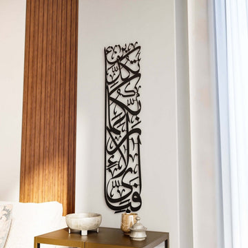 Vertikale Metall-Wandkunst Sure Rahman Vers 13 in Schwarz, hohe Säule arabischer Kalligrafie über einem Beistelltisch