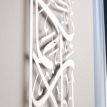 Vertikale Metall-Wandkunst Sure Rahman Vers 13 in Mattsilber, Blick schräg nach oben auf Buchstaben und Schatten