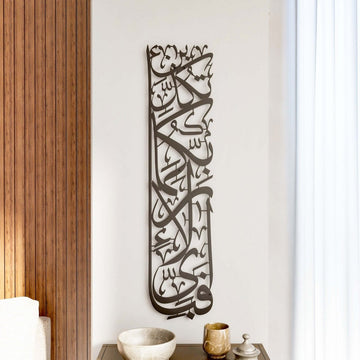 Vertikale Metall-Wandkunst Sure Rahman Vers 13 in Schwarz an weißer Wand neben einer holzvertäfelten Wand