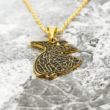 Nahaufnahme des goldenen Derwisch-Anhängers mit der in die Derwischfigur geschnittenen Kalligrafie