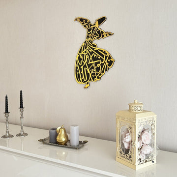 Gold whirling dervish wooden wall art on a wall above a sideboard with a lantern, close view