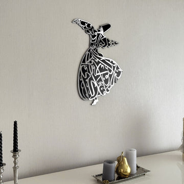 Silver whirling dervish wooden wall art on a wall, angled view above a tray on a sideboard