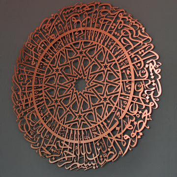Kupferfarbene runde Metall-Wandkunst mit Sure Al-Fatihah an einer grauen Wand, leicht schräg