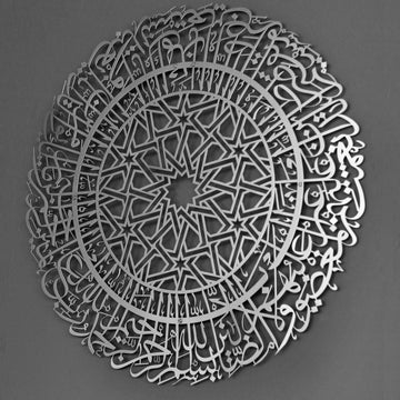 Silberne runde Metall-Wandkunst mit Sure Al-Fatihah an einer grauen Wand, leicht schräg
