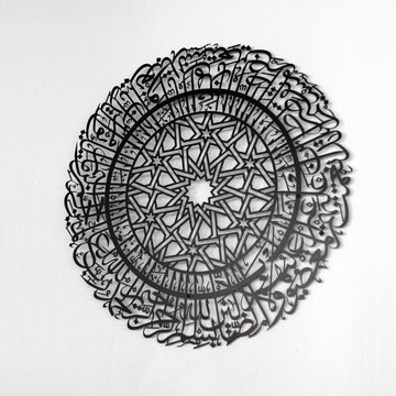 Schwarze runde Metall-Wandkunst mit Sure Al-Fatihah an einer weißen Wand, Ansicht von rechts