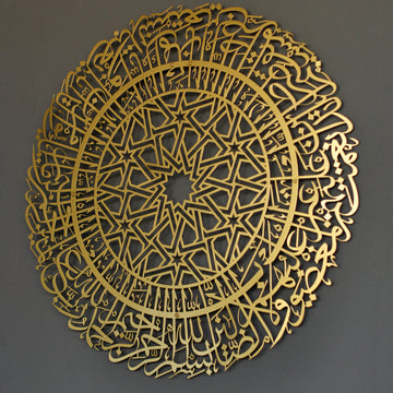Goldene runde Metall-Wandkunst mit Sure Al-Fatihah an einer grauen Wand, Ansicht von rechts