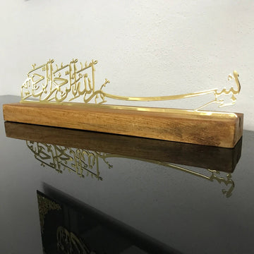 ديكور طاولة بخط البسملة من المعدن الذهبي اللامع على حامل خشبي بني متوسط، منظر أمامي