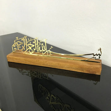 ديكور طاولة بخط البسملة من المعدن الذهبي اللامع على حامل خشبي بلون الكرز (داكن)، بزاوية من اليسار