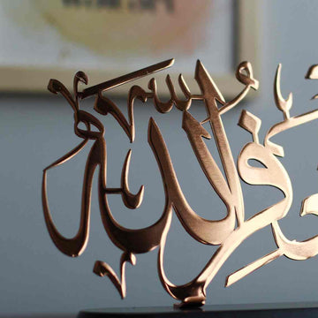 Side close-up of the shiny copper Astaghfirullah calligraphy and its stand fixing