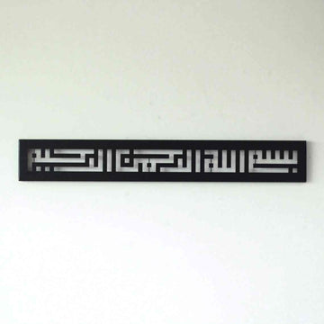 Metall-Wandkunst mit Bismillah in Kufi-Schrift in Schwarz, mittig an einer weißen Wand, Vorderansicht aus der Ferne