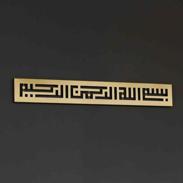 Metall-Wandkunst mit Bismillah in Kufi-Schrift in Gold, an einer dunkelgrauen Wand, leicht schräg